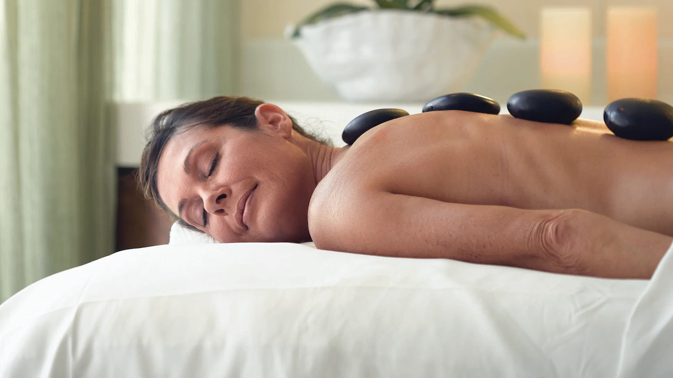 Frau bei einer Hot Stone Massage auf dem Kreuzfahrtschiff Riviera